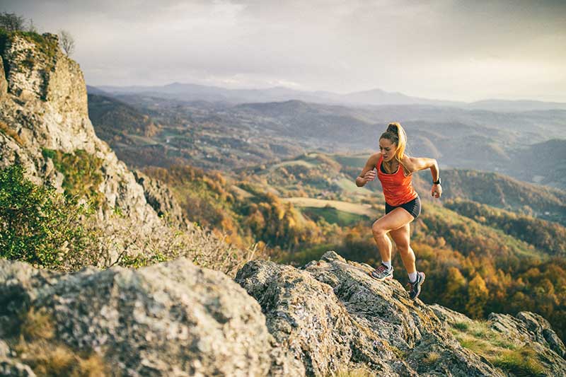 Lady running on hill - Sport injury chiropractor Lady running on hill - Sport injury chiropractor