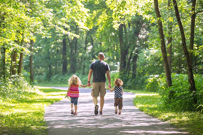Man walking in woods with children - family chiropractor