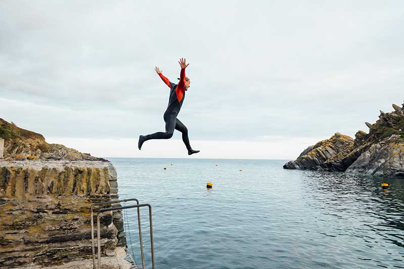 Happy man Man jumping into ocean