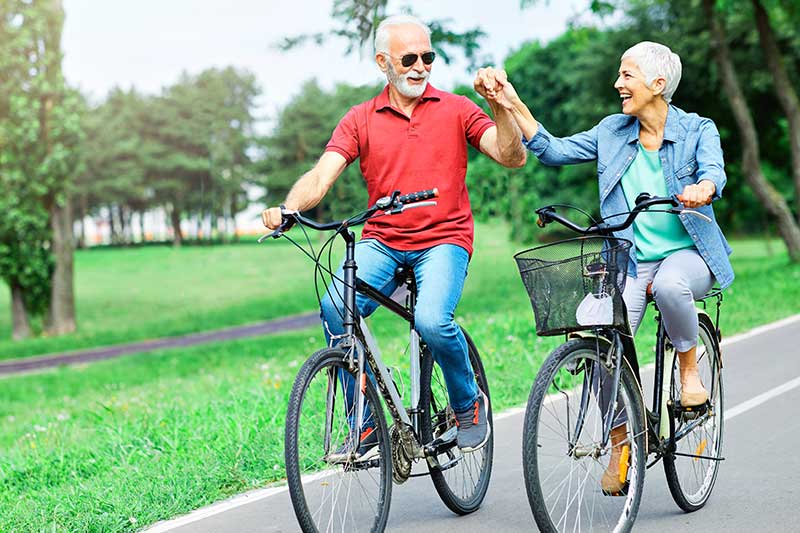 Older couple riding bikes - pain chiropractor
